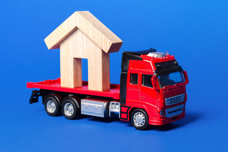 Red truck carrier with a house figure on a blue background