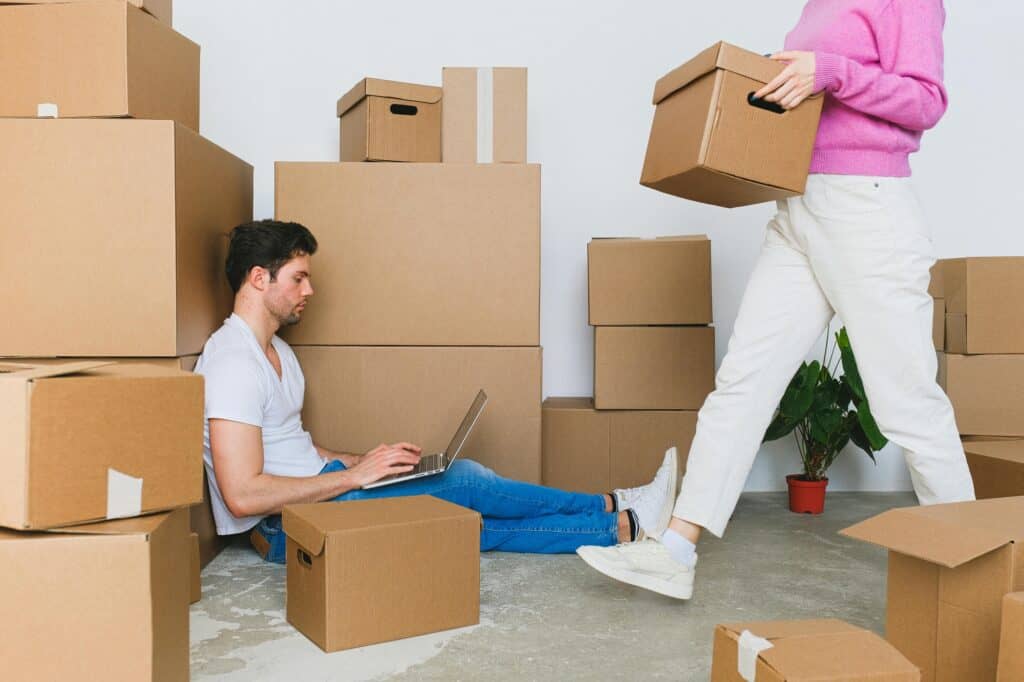 A couple is surrounded by carton boxes in the concept of moving to Balham