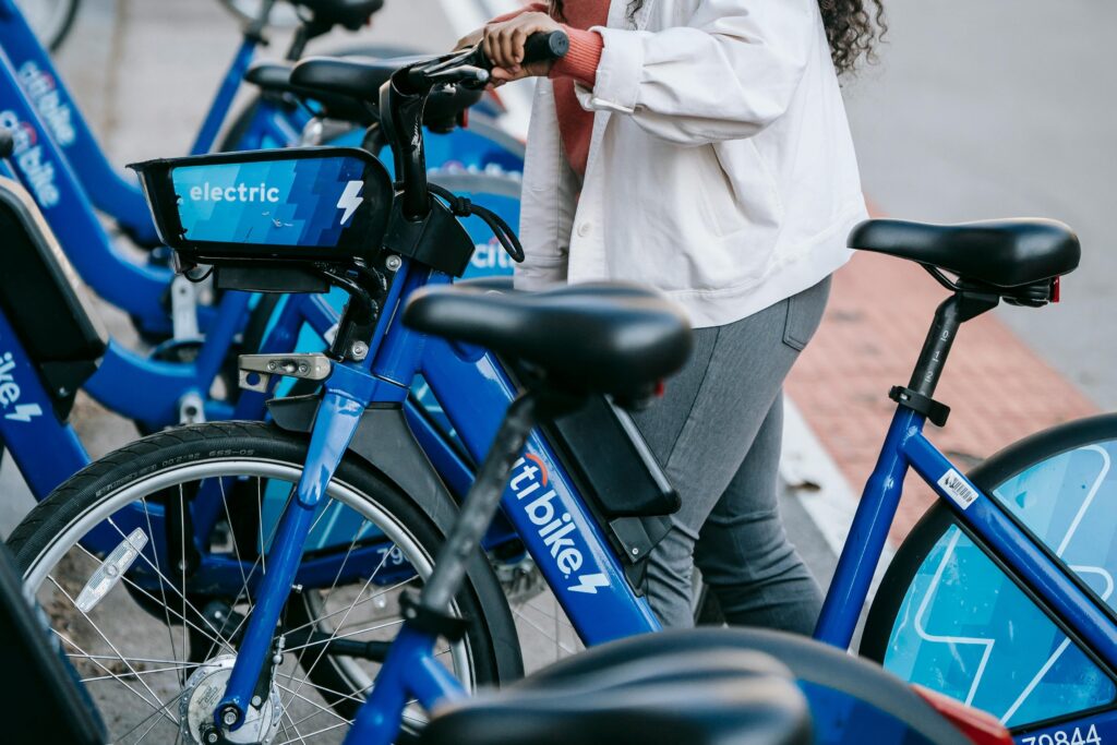 A line of bicycles for hire and a woman holding one bike