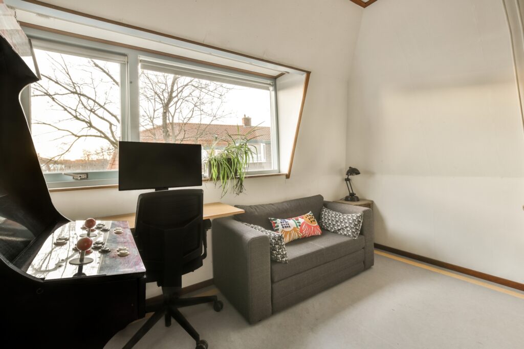 A small living room with a sofa and a computer table