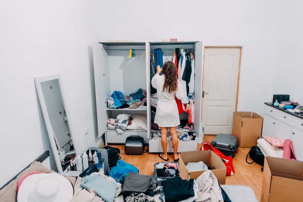 A woman sorting her clothes from the cabinet