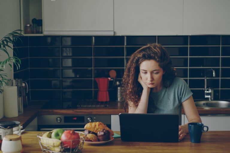 A young woman in front of her laptop in the concept of 'How to Plan and Prepare for Home Removals'.